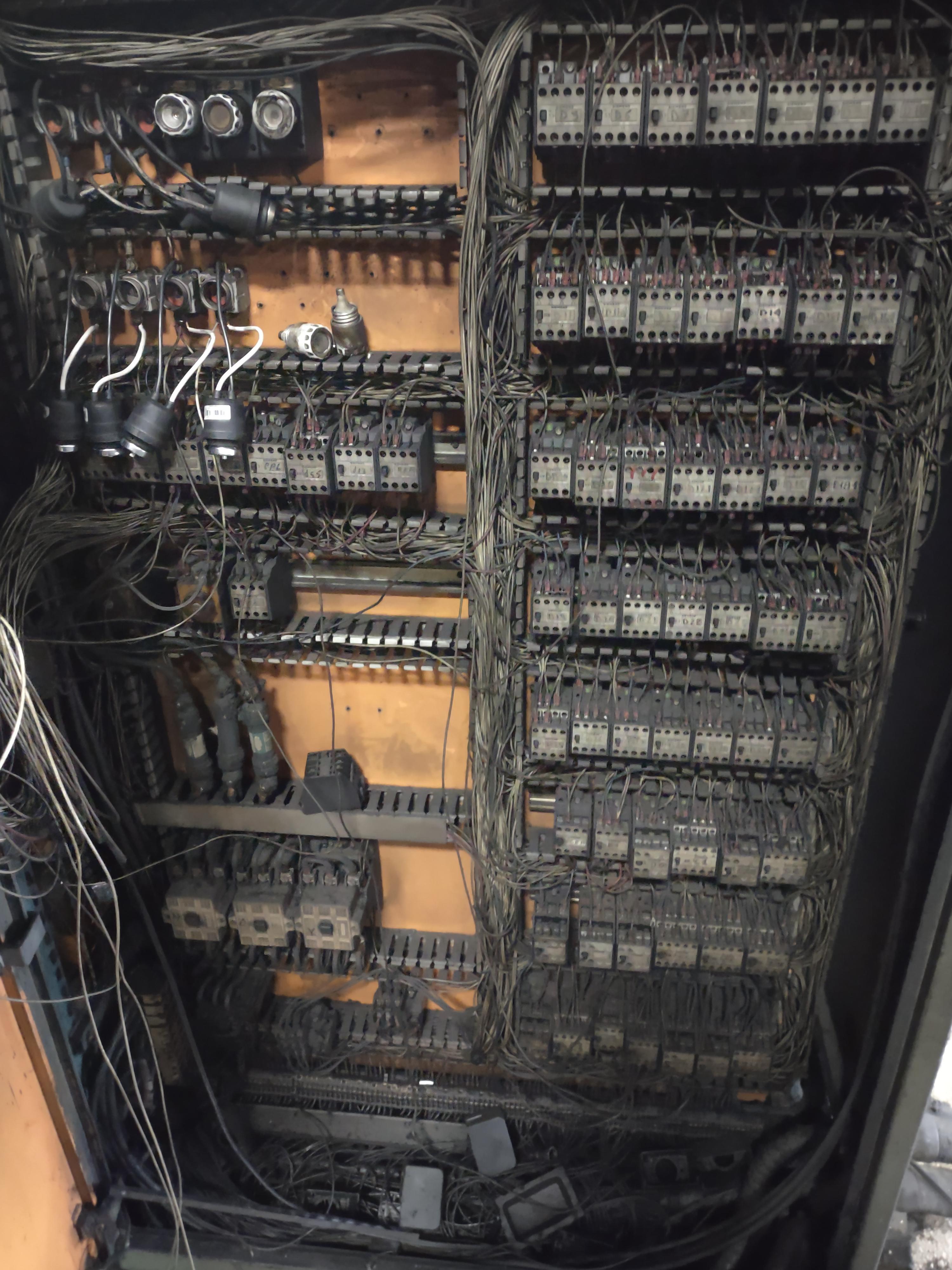 Pre-PLC industrial relay control cabinet used in factories before programmable logic controllers replaced hard-wired relay logic